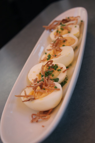 Harissa spiced Deviled Eggs with Onion strings and Chives